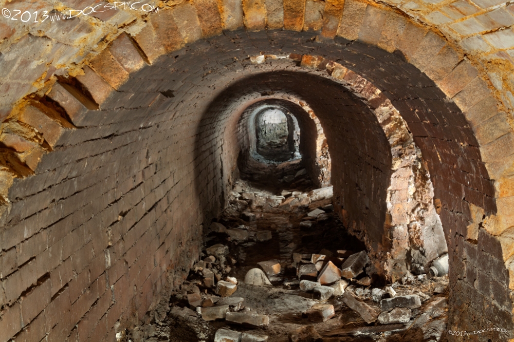 Another view looking east down the tunnel. There is some light visible from outside at the end - the last ventilation port hasn't completely filled in with debris. 