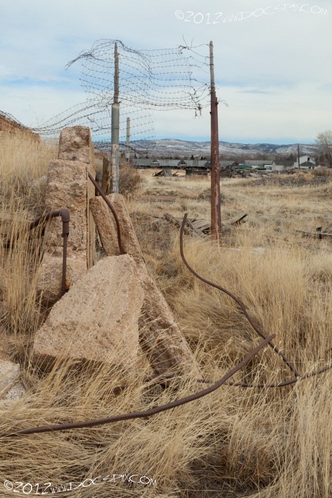 A wider view of the rebar on the pipe. Remnants of an old fence can be seen in the background.
