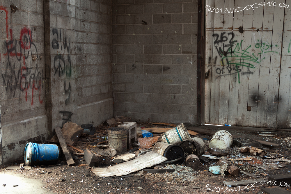 A number of oil containers and debris occupy the south west corner of the factory floor. 