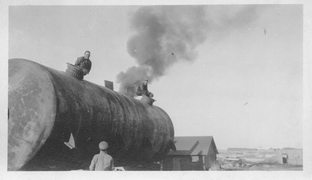 A pair of workers sit on top of one of the tanks that would be placed on top of the foundations. (Courtesy of the American Heritage Center, University of Wyoming, digital collections)