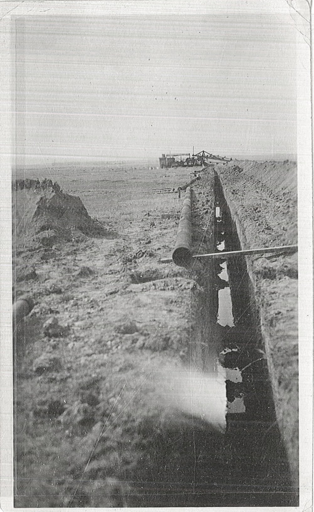A trench has filled with water shortly after being excavated. The exact use for the pipe is unknown. 