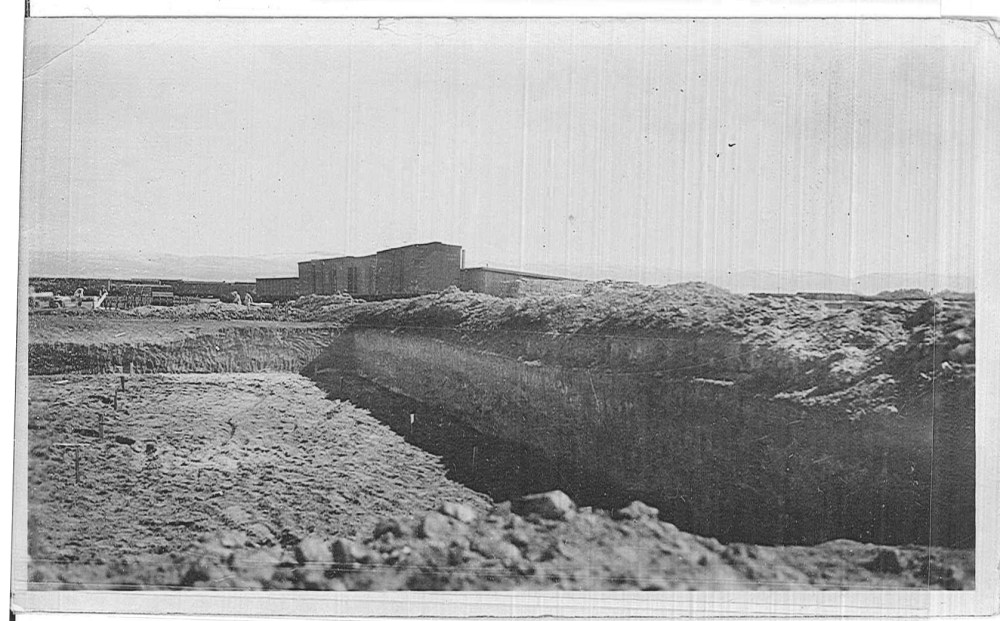 Earth has been excavated to place forms for a foundation, (possibly the laboratory).